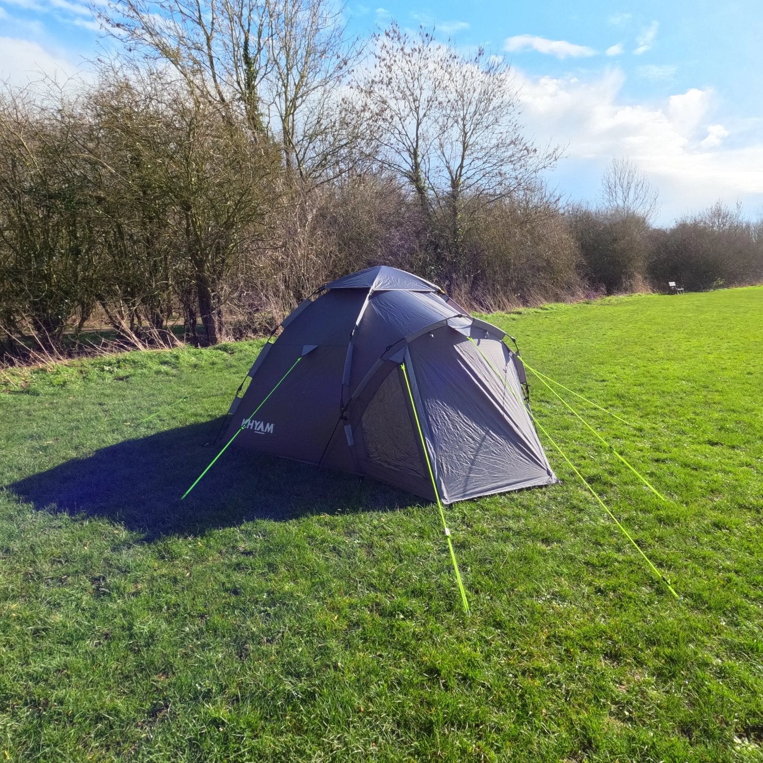 LocTek Igloo MK3 Fast Pitch Tent - 3 Man Tent Khyam on grass camping ground surrounded by winter trees and hedges on sunny day with blue sky.